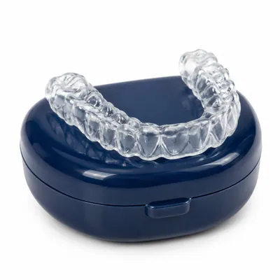 Clear custom night guard resting on a navy retainer case