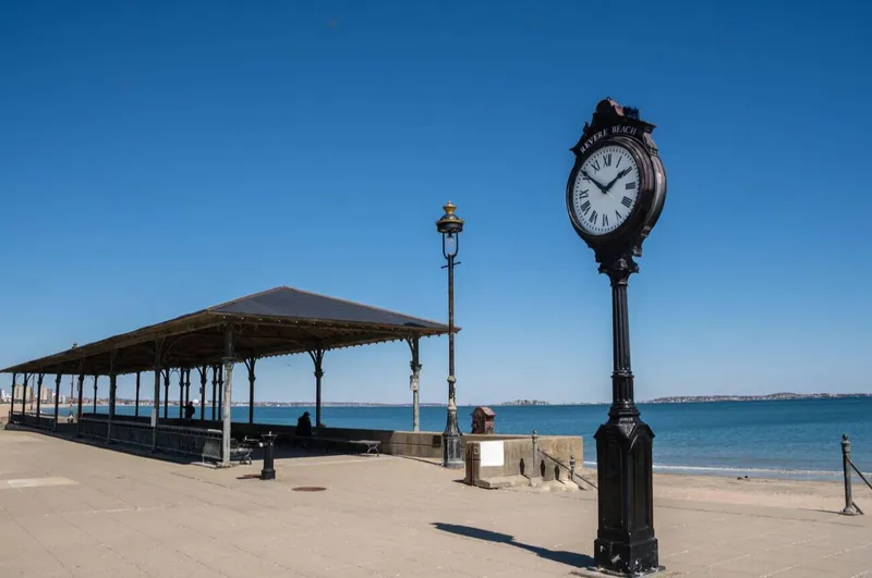 Revere Beach with its historic standing clock, pavilion and ocean shoreline under a clear sky
