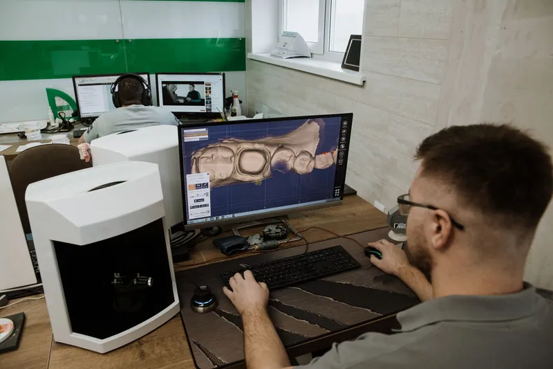 Technician designing a restoration in dental CAD software