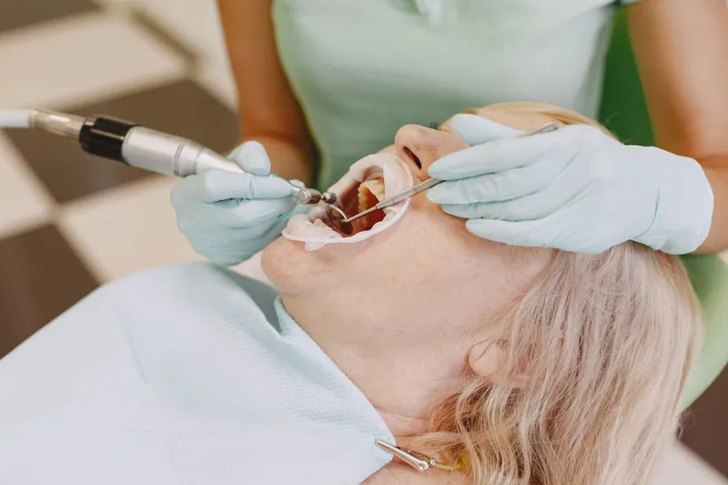 Dentist working on a patient with a handpiece and mirror
