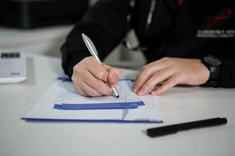 Hand writing on a prescription form with a pen